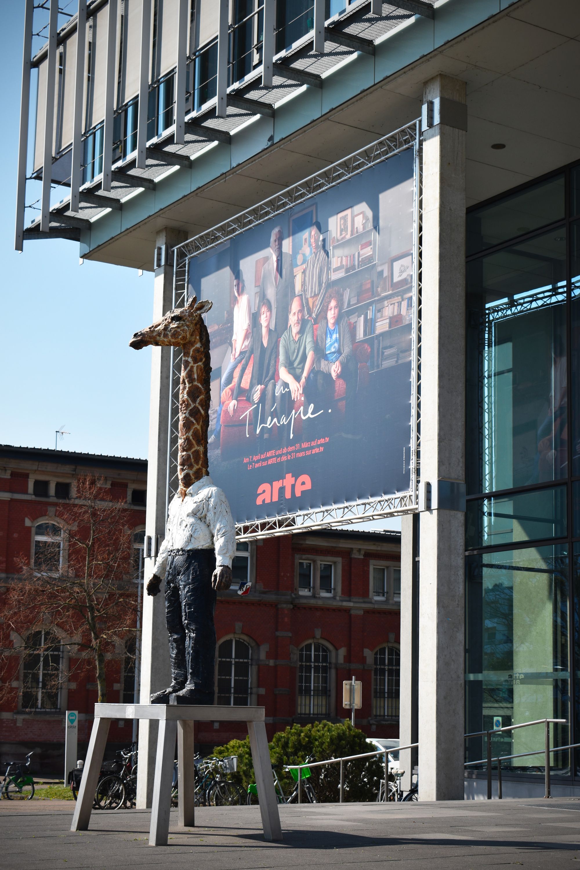 The Homme Girafe in front of Arte buildings