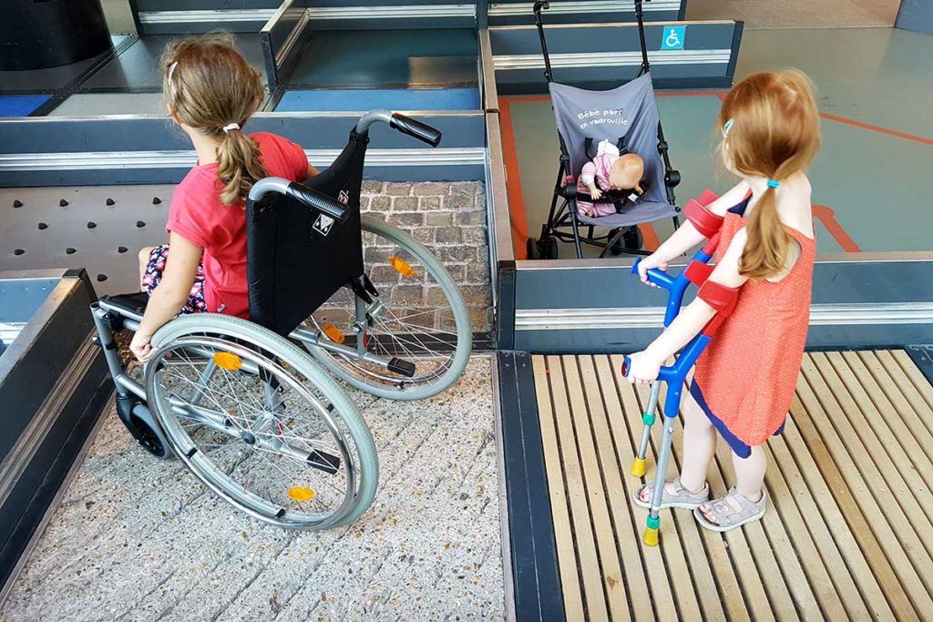 Children discovering the course in a wheelchair and with crutches