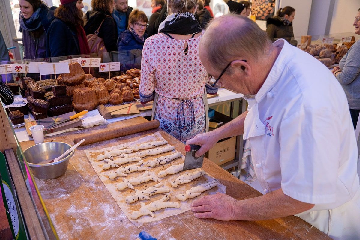 A man baking Mannele (a traditional bakery from Alsace) at the Christmas market