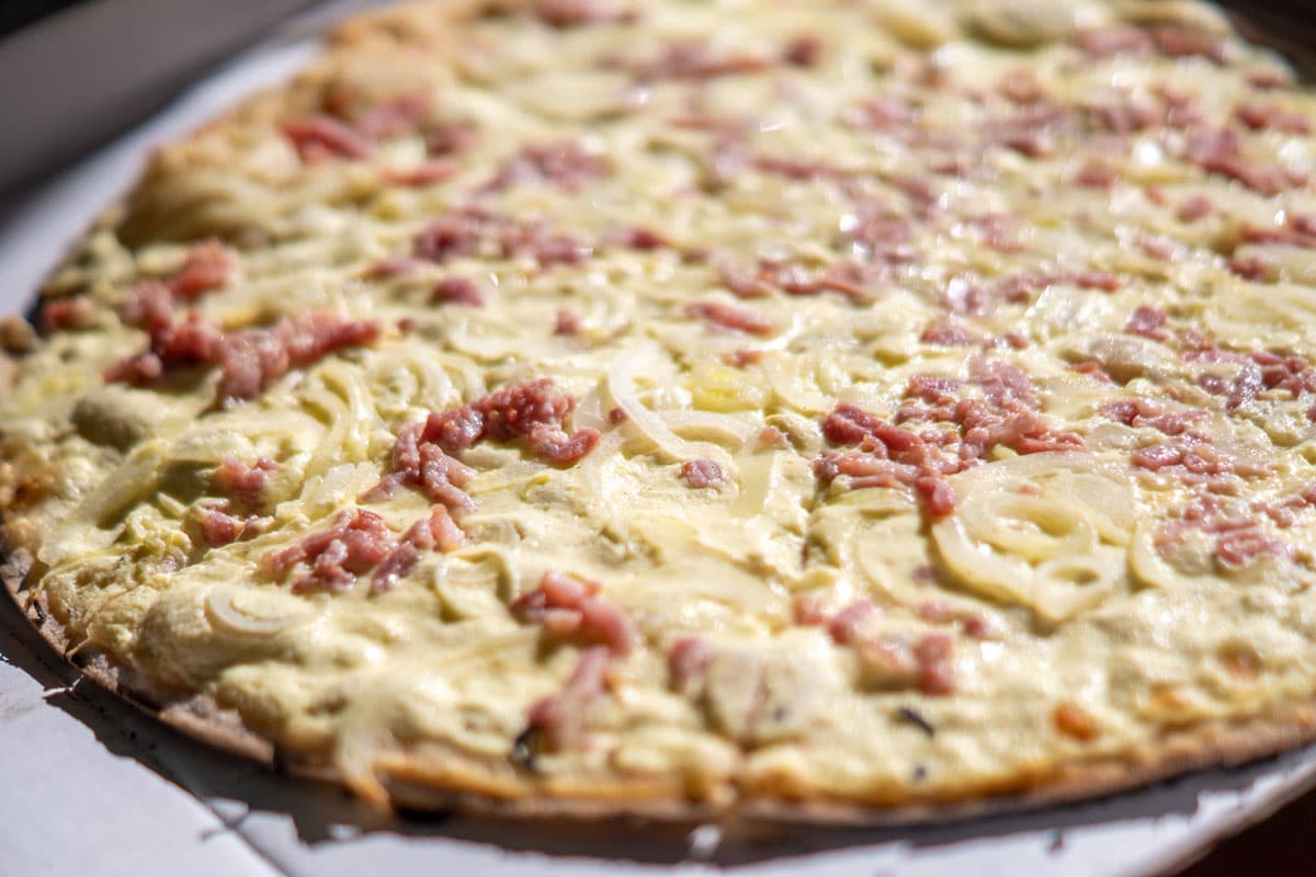 Tarte flambée based on cream or cottage cheese, onions and bacon