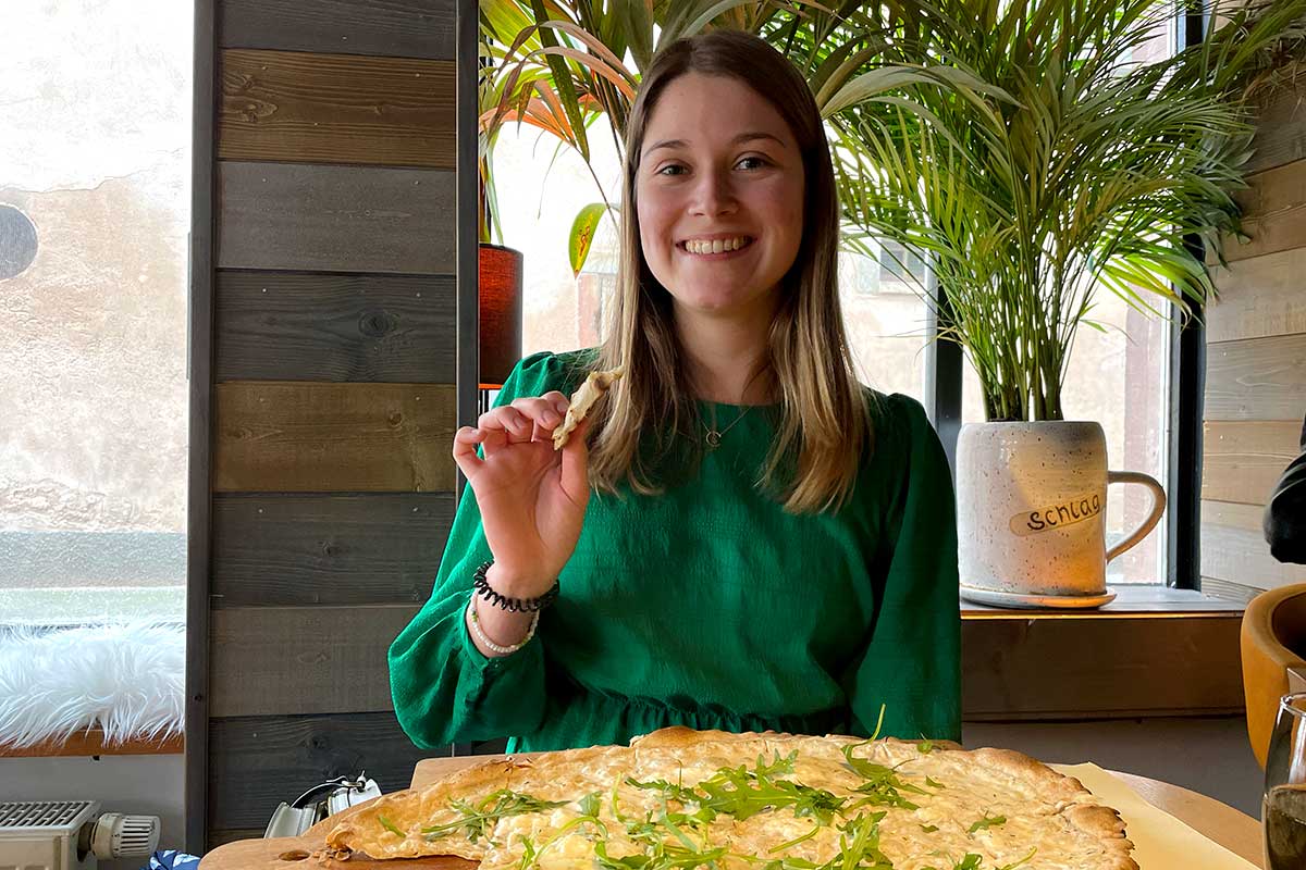 Woman eating tarte flambee in Strasbourg