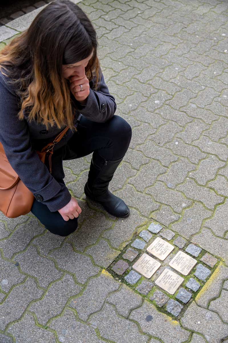 Woman commemorating in front of stolpersteine